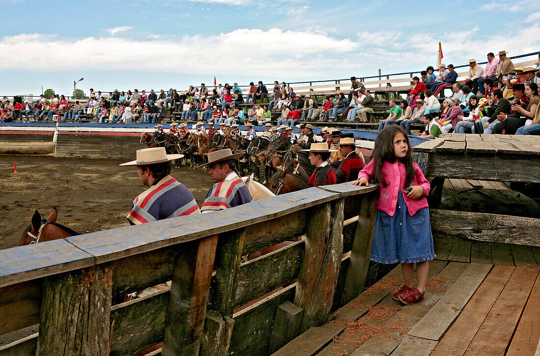 Young girl watching a rodeo in Conchi, Chiloé, Chile, South America