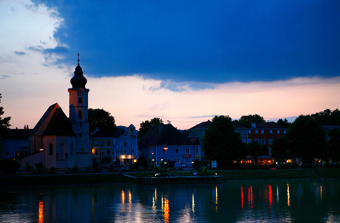 View of village with church over river Danube at night, Brandstatt, Upper Austria, Austria