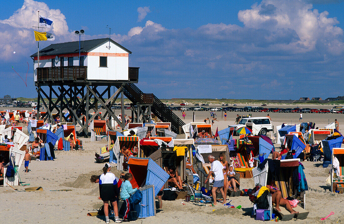Menschen in Strandkörben vor einem Stelzenhaus am Strand, St. Peter Ording, Halbinsel Eiderstedt, Schleswig-Holstein, Deutschland, Europa