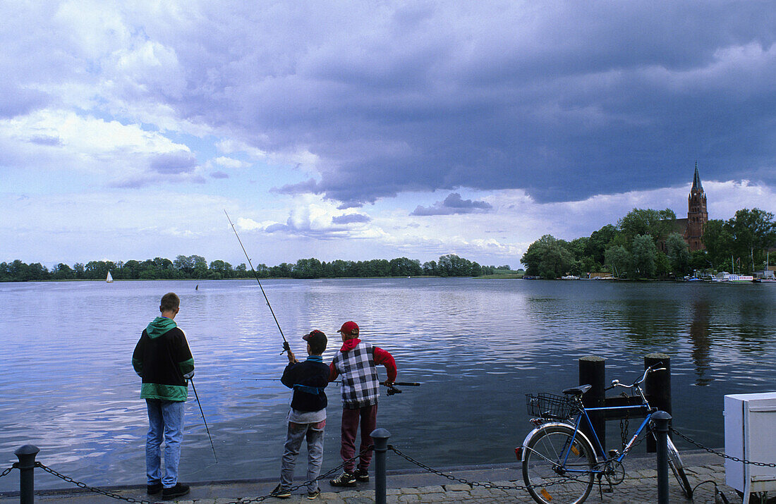 Children fishing at lake Muritz, Robel, Mecklenburg Western-Pomerania, Germany