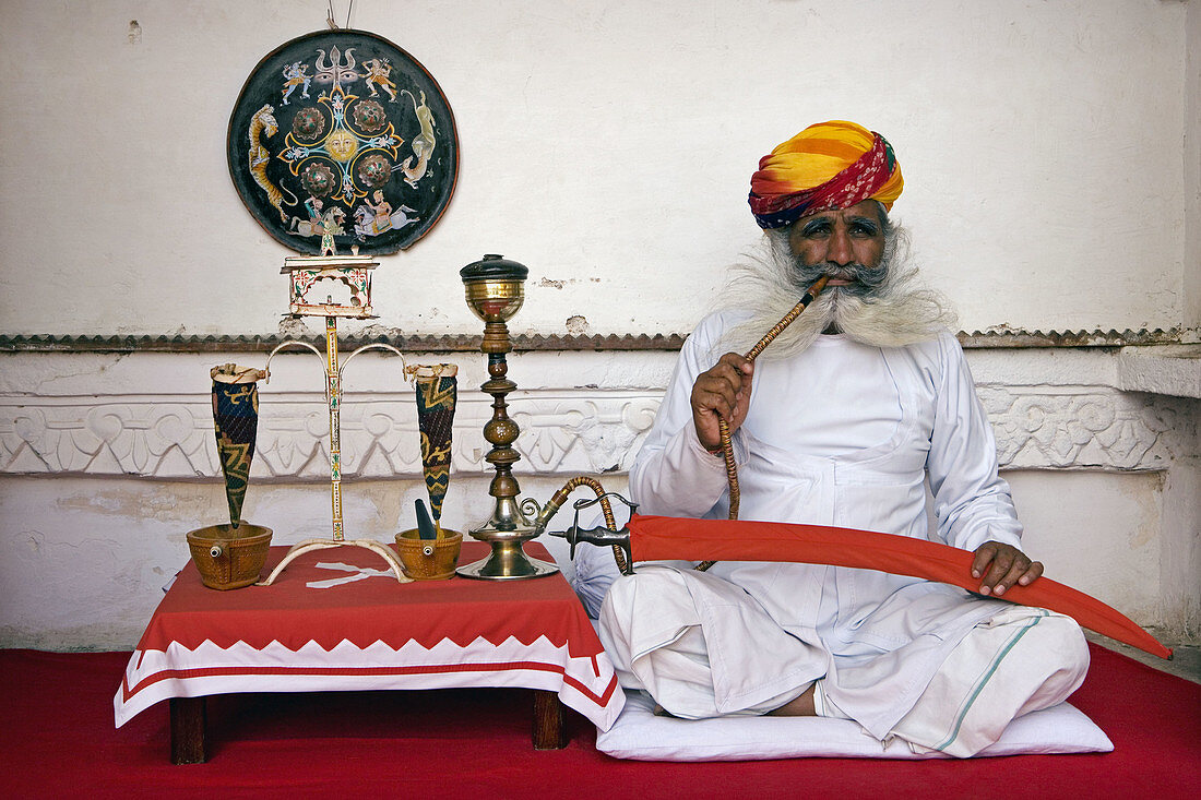 Senior man sitting at a veranda of a museum, Meherangarh Museum, Jodhpur, Rajasthan, India.