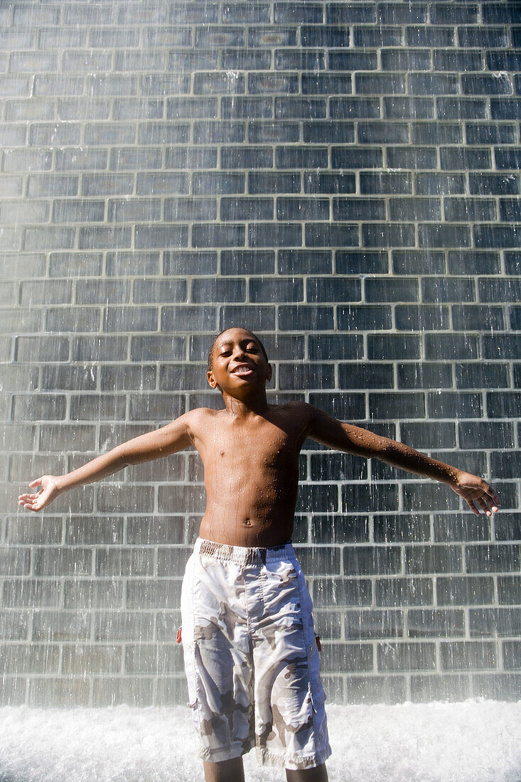 BOY STANDING UNDER, CROWN FOUNTAIN, MILLENNIUM PARK, CHICAGO, ILLINOIS, USA
