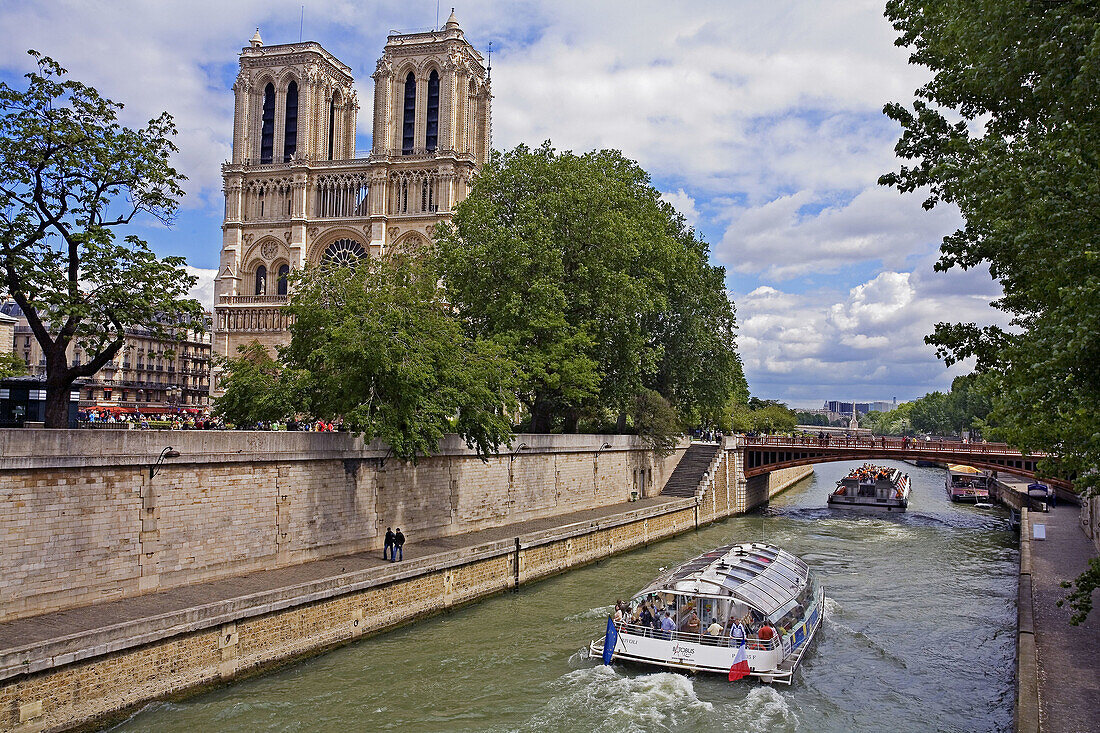 Sightseeing boat in front of Notre-Dame cathedral at Seine River. Paris. France