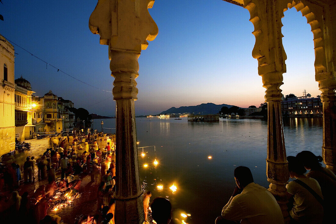Making offerings 'puja' to the lake Pichola during a holy day, Gangaur Ghat. Udaipur. Rajasthan. India