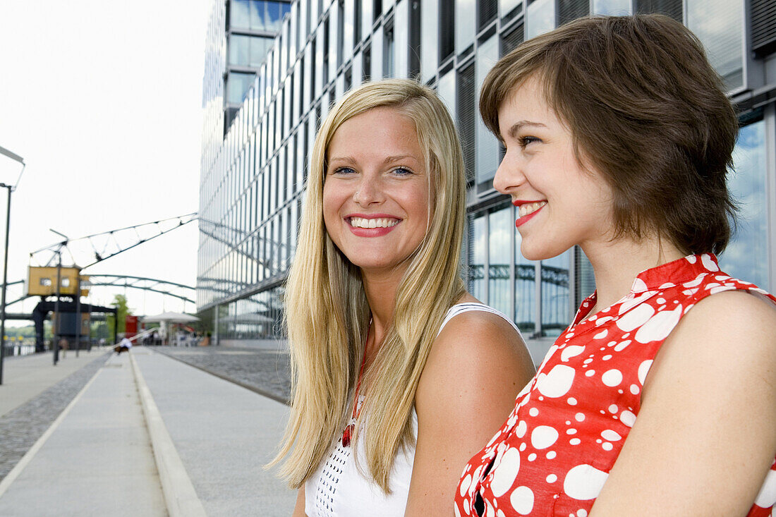Two young women smiling, Cologne, North Rhine-Westphalia, Germany