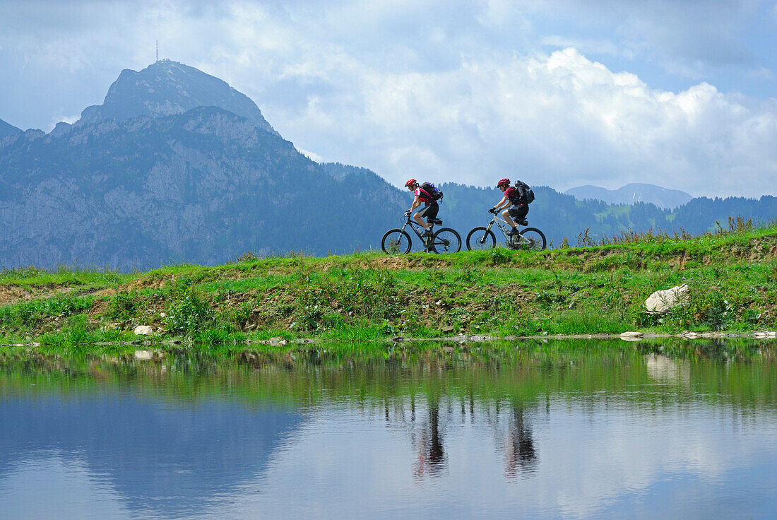 two mountain bikers in front of Wendelstein, lake with reflections, Wendelstein range, Bavarian range, Upper Bavaria, Bavaria, Germany