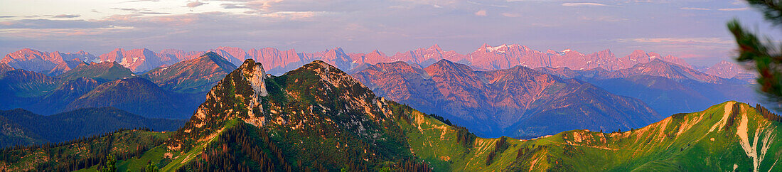 Buchstein, Rossstein and Hochplatte with Karwendel range in alpenglow in background, panorama from Hirschberg, Bavarian foothills, Bavarian range, Upper Bavaria, Bavaria, Germany