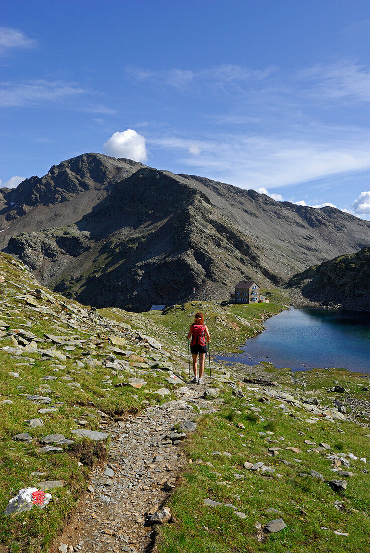 junge Frau auf dem Weg zur Flaggerschartenhütte mit See, Marburg-Siegener Hütte, Rifugio Forcella di Vallaga, Sarntaler Alpen, Südtirol, Alta Badia, Italien