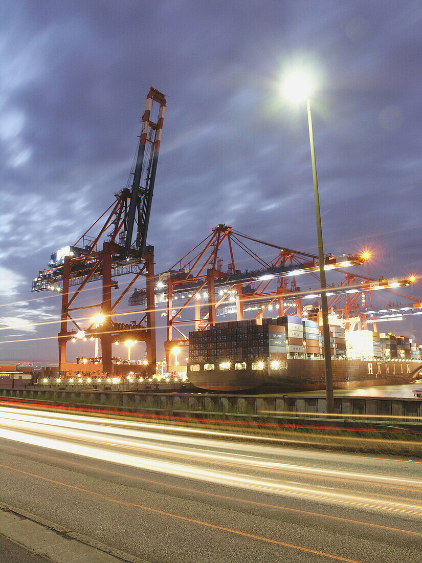 Container cranes at container port in the night, Hamburg, Germany