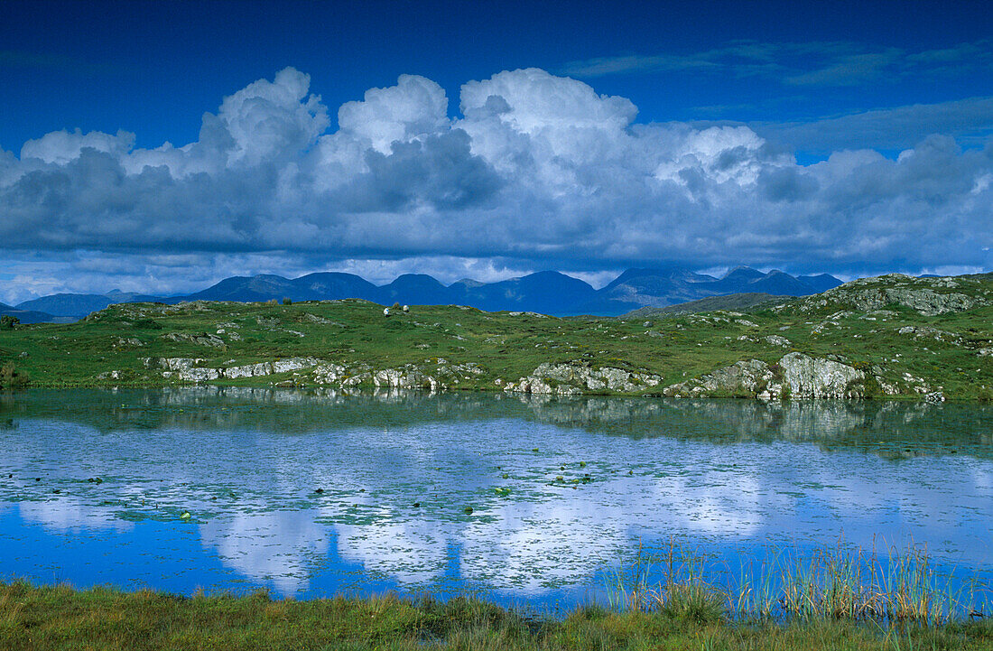 Twelve Bens mountain range and reflection of the clouds in a lake, Na Beanna Beola, Connemara, Co. Galway, Ireland, Europe