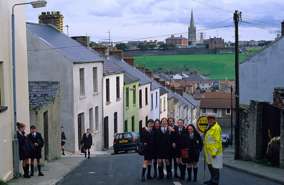 Crossing guard with students on a street at the Bogside, Derry, County Londonderry, Ireland, Europe