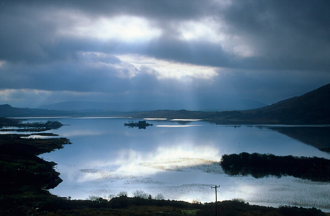Cloud cover and sigle sunbeams over the Lough Corrib, Connemara, County Galway, Ireland, Europe