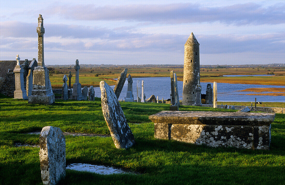 Ruins of the monastery of Clonmacnoise with gravestones and tower, County Offaly, Ireland, Europe