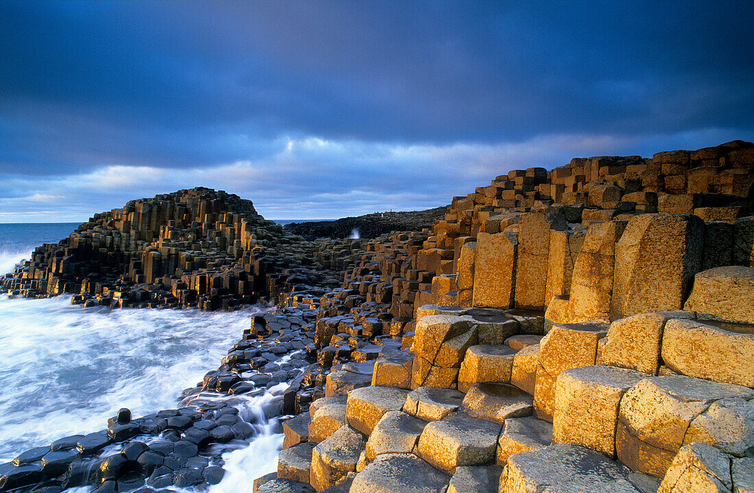 Giant’s Causeway, Nordirland, World Heritage Site, Damm des Riesen, Basaltsäulen an der Küste unter Wolkenhimmel, County Antrim, Europa