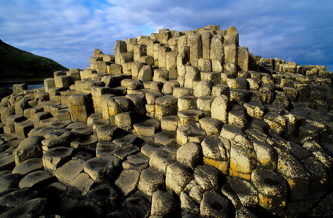 Giant’s Causeway, Nordirland, World Heritage Site, Damm des Riesen, Basaltsäulen an der Küste unter Wolkenhimmel, County Antrim, Europa