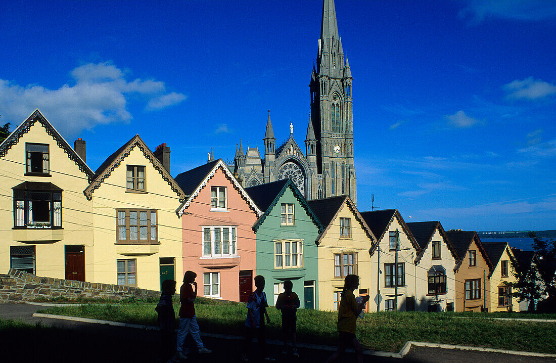 Colourful facades of houses at the Old Town, in the background St. Colman's cathedral, Cobh, County Cork, Ireland, Europe