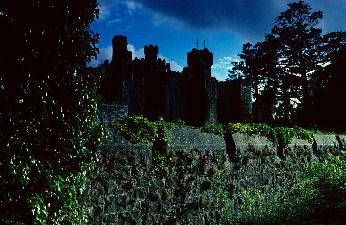 View at the silhouette of Ashford Castle under dark clouds, County Mayo, Ireland, Europe