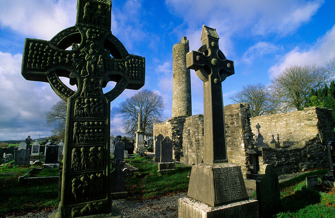 High crosses in front of the ruins of Monasterboice abbey under clouded sky, County Louth, Ireland, Europe