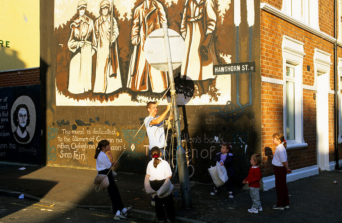 Kinder spielen vor einer bemalten Hauswand, Falls Road, Belfast, County Antrim, Irland, Europa