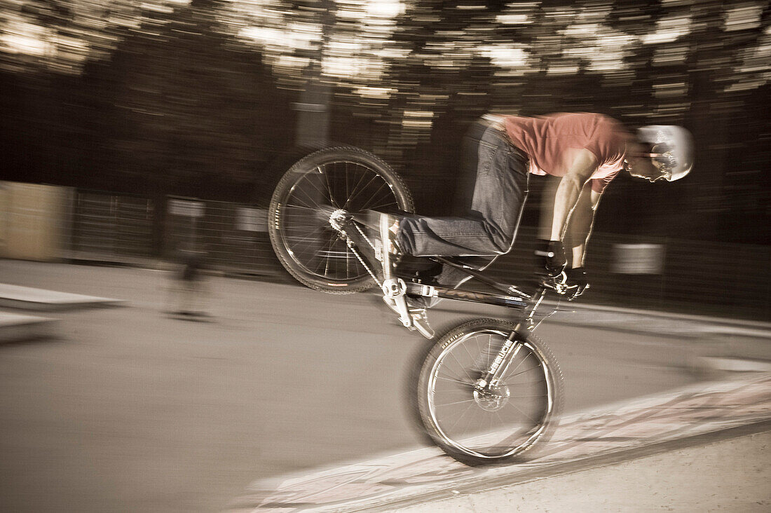 A teenager on his trial bike during a stunt in the evening, Wagram, Austria
