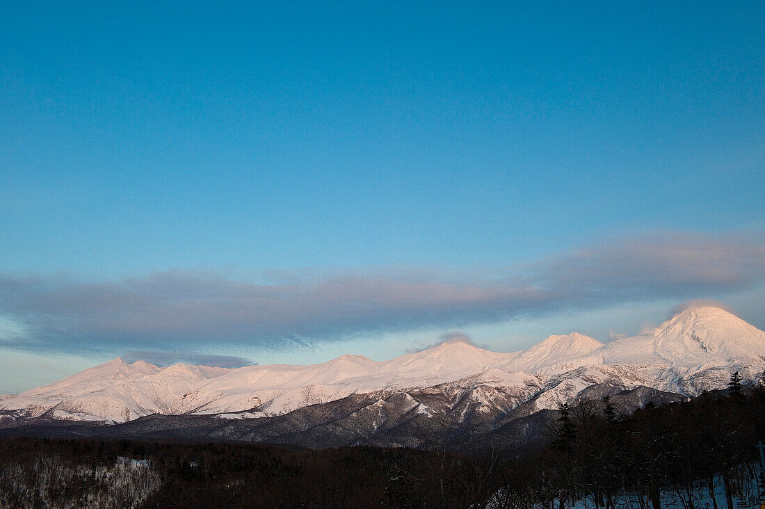 Schneebedeckte Bergkette unter Wolken, Hokkaido, Japan, Asien
