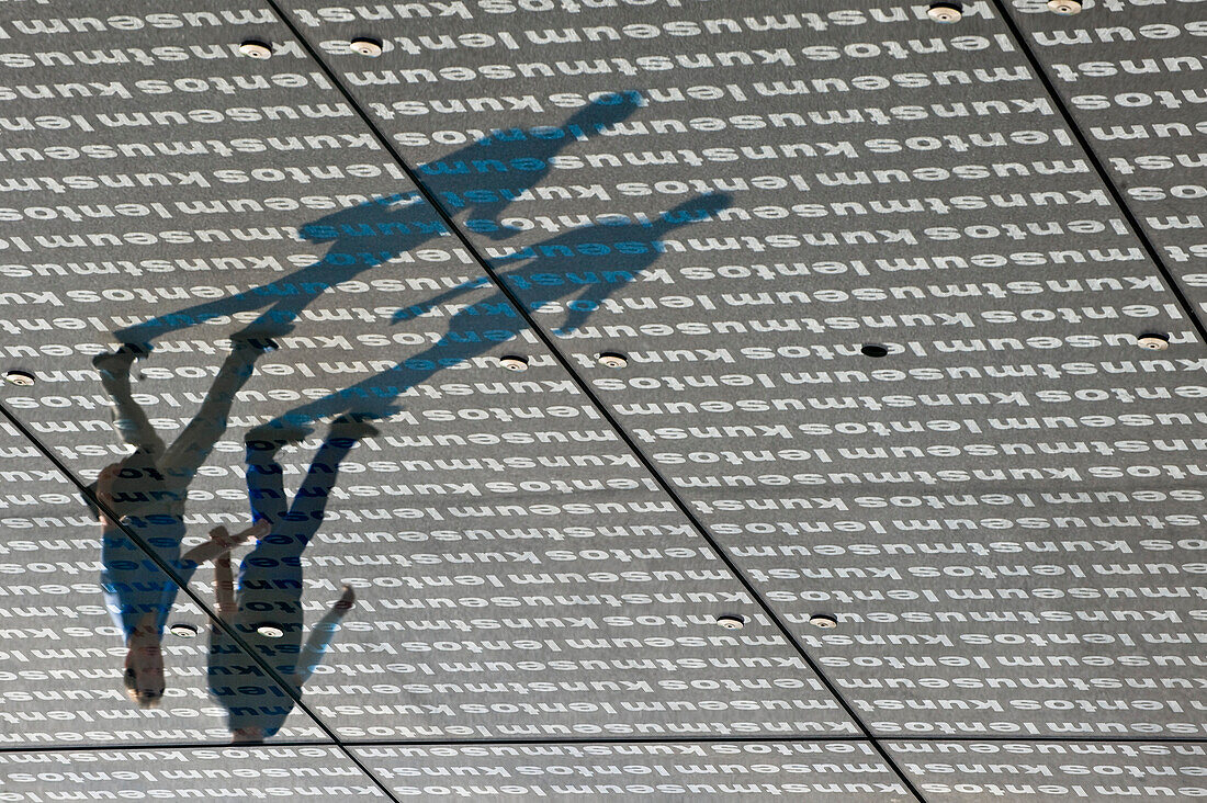 Zwei Männer spiegeln sich im Dach des Kunstmuseums Lentos, Linz, Oberösterreich, Österreich