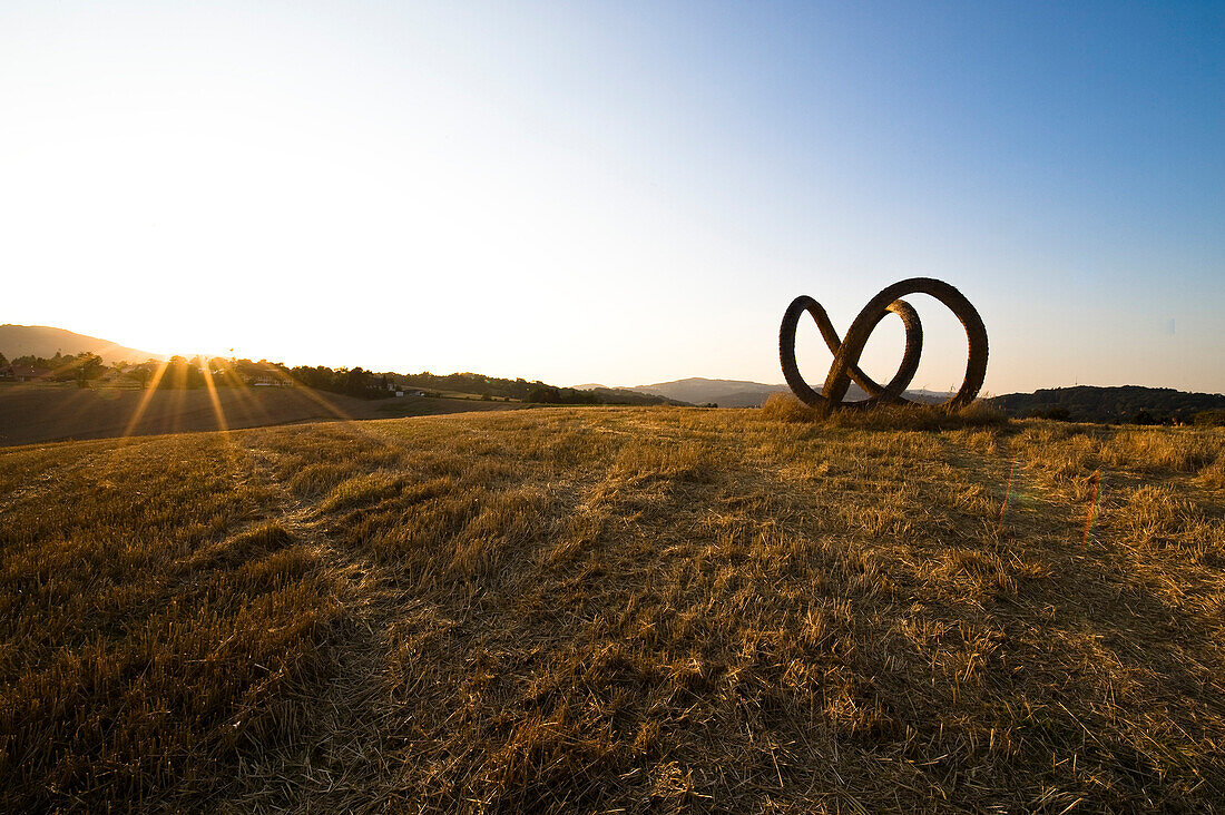 Skulptur aus Stroh auf einem Feld in der Abenddämmerung, Linz, Oberösterreich, Österreich