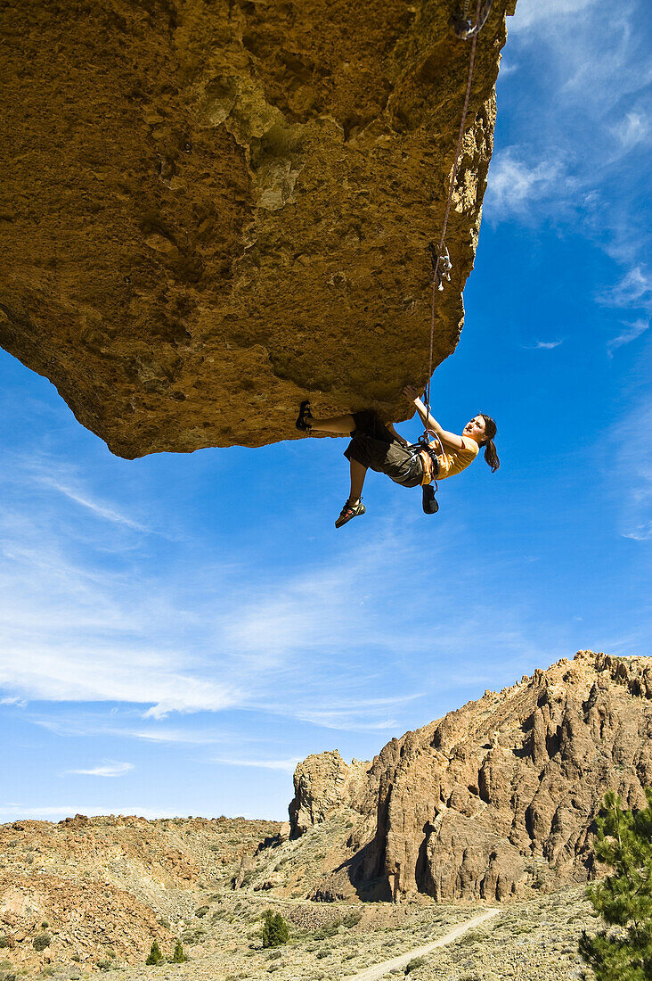 Frau klettert im Überhang im Teide Nationalpark, Teneriffa, Kanarische Inseln, Spanien