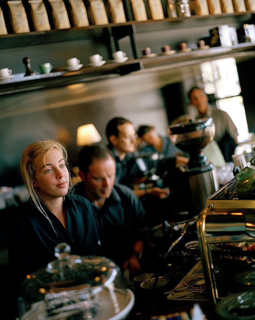 Junge Frau bedient alte italienische Espressomascine E61 im Mojo Café, Wellington, Nordinsel, Neuseeland