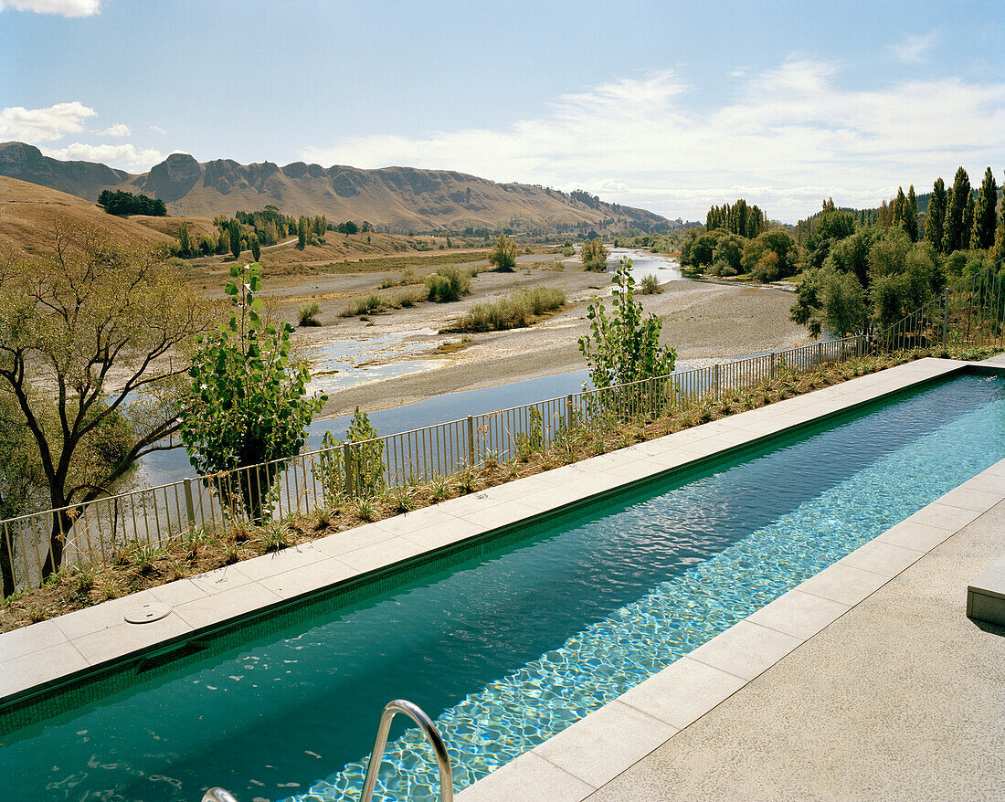 Schwimmbad eines Ferienhauses im Sonnenlicht mit Blick auf Tukituki River, Havelock North, Hawke's Bay, Nordinsel, Neuseeland