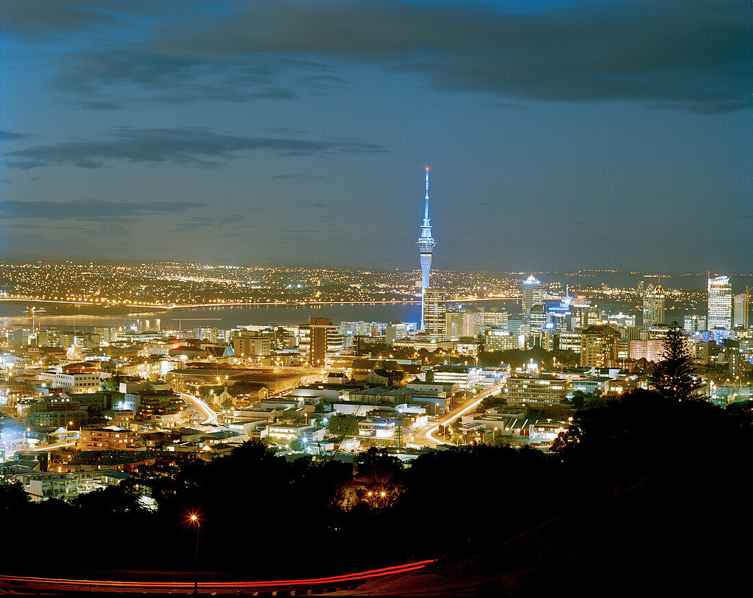 Blick auf den beleuchteten Central Business District mit Sky Tower bei Nacht, Auckland, Nordinsel, Neuseeland