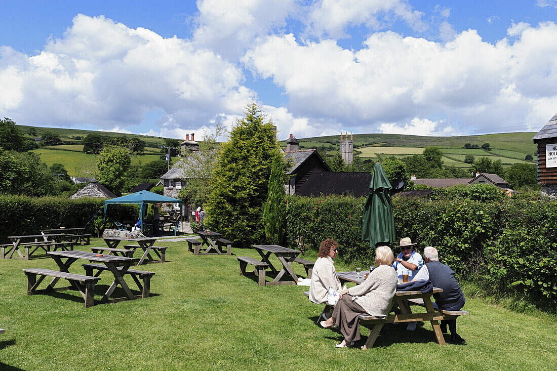 Gäste sitzen im Garten des Ruggelstone Inn, Widecombe-in-the-Moor, Nationalpark Dartmoor, Devon, England, Großbritannien