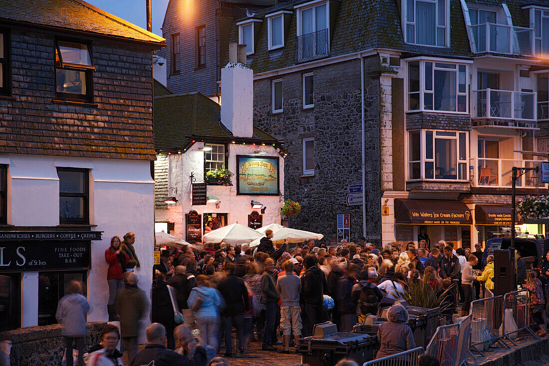 Menschenmenge auf einem Platz am Abend, St. Ives, Cornwall, England, Großbritannien