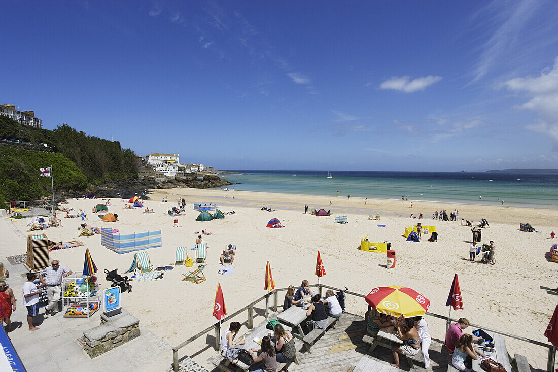 Leute sonnen sich am Porthminster Beach, St. Ives, Cornwall, England, Großbritannien