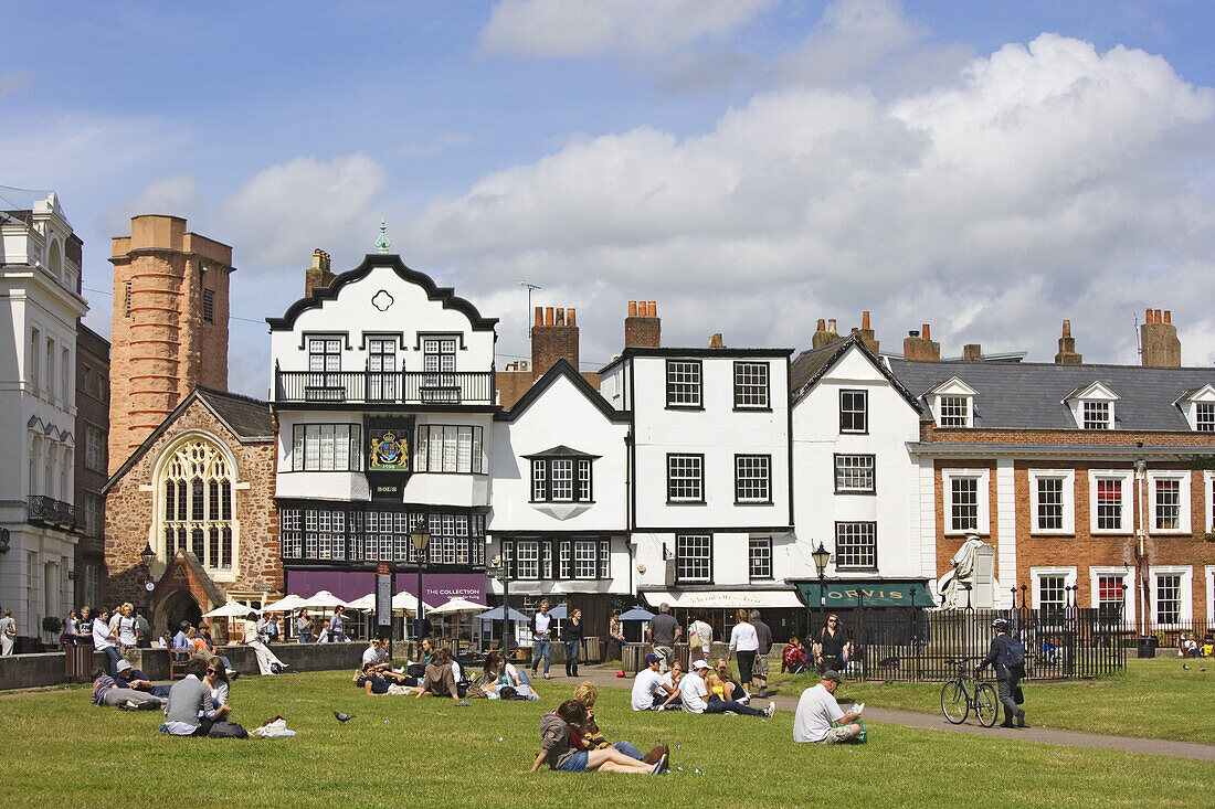 People relaxing on gras at Cathedral Close, Exeter, Devon, England, United Kingdom