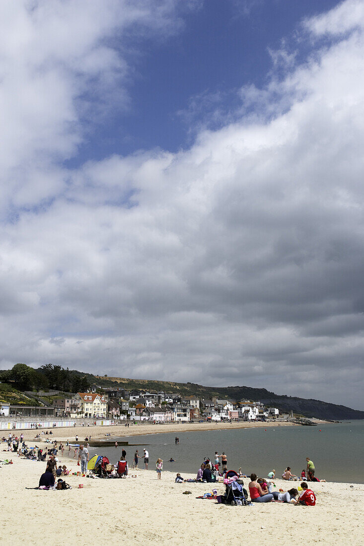 Leute entspannen am Strand, Lyme Regis, Dorset, England, Großbritannien