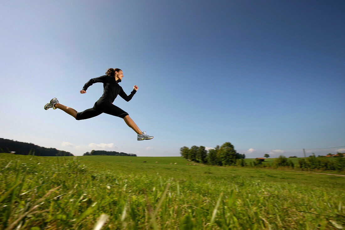 Woman jumping on meadow