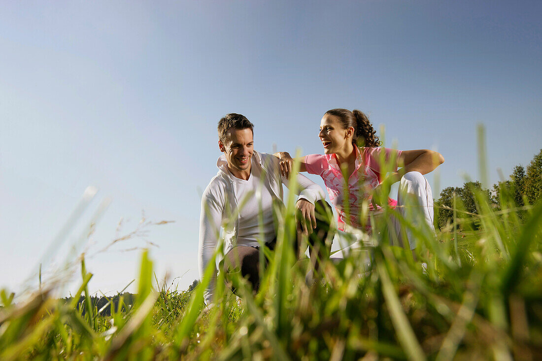 Couple crouching in grass
