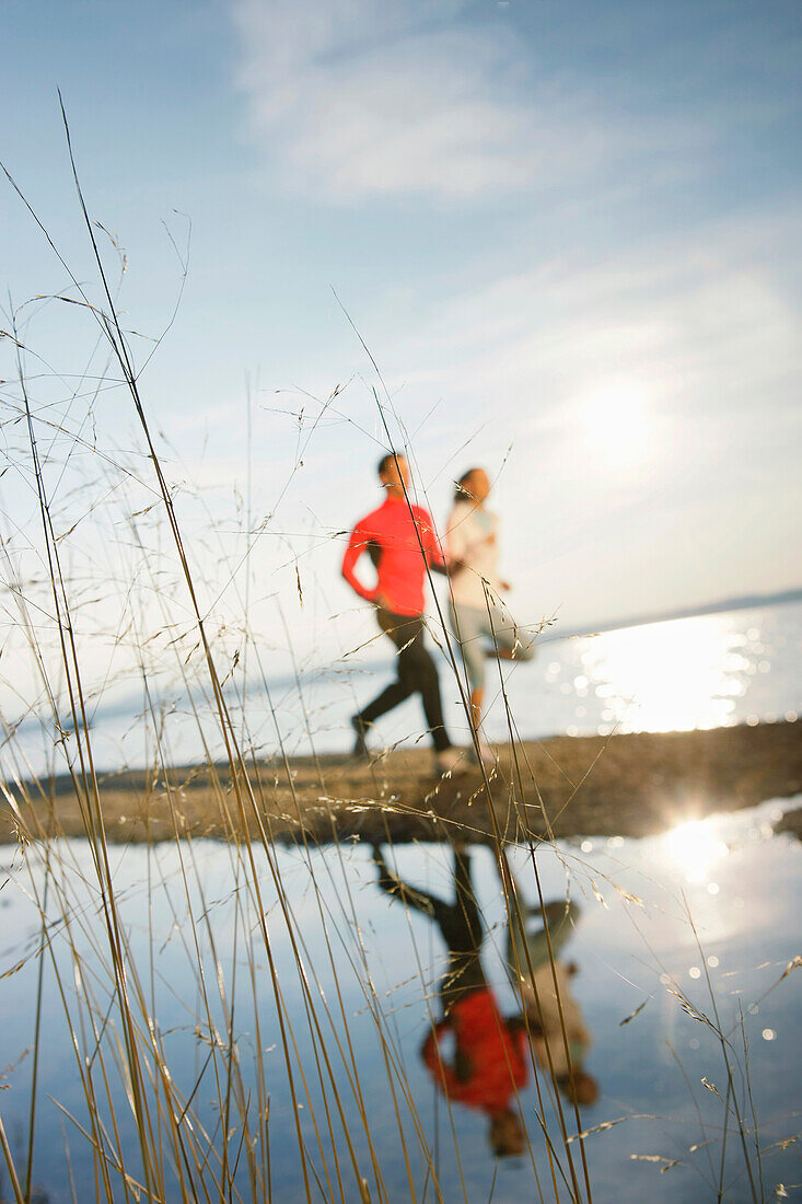 Couple jogging along lake Starnberg, Ambach, Bavaria, Germany