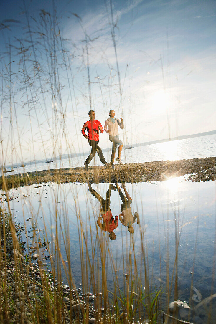 Couple jogging along lake Starnberg, Ambach, Bavaria, Germany