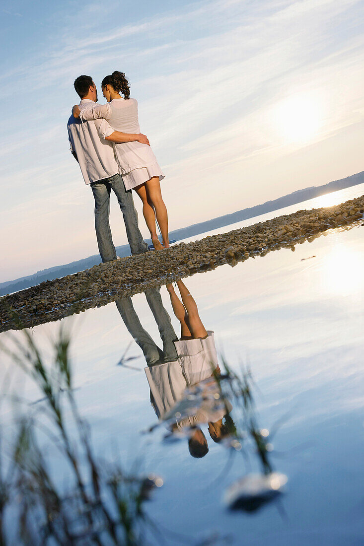 Couple standing at lakeshore, Ambach, Lake Starnberg, Bavaria, Germany