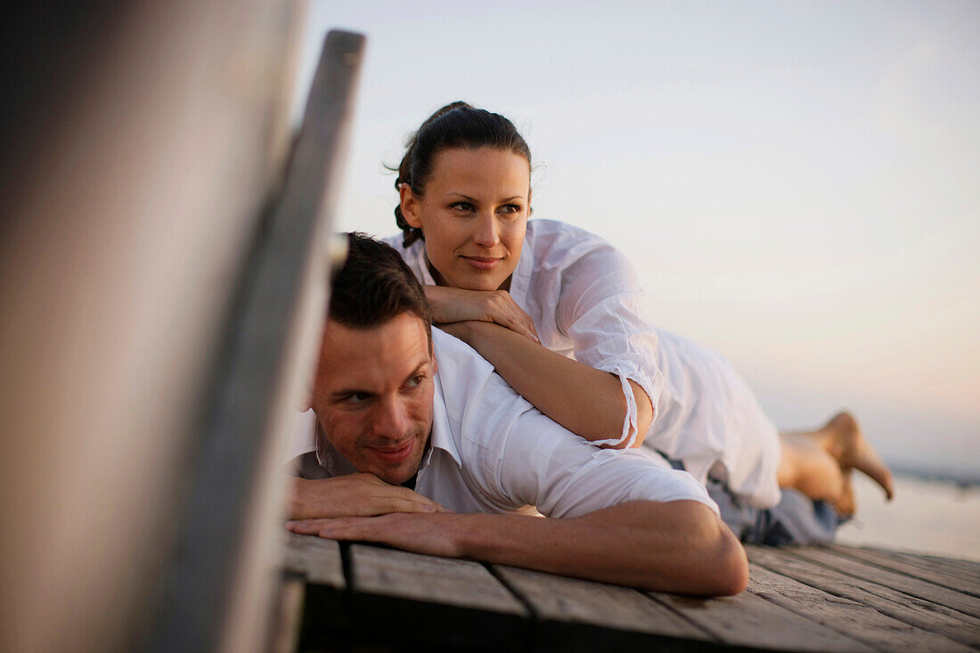 Paar liegt auf einem Steg, Ambach, Starnberger See, Bayern, Deutschland