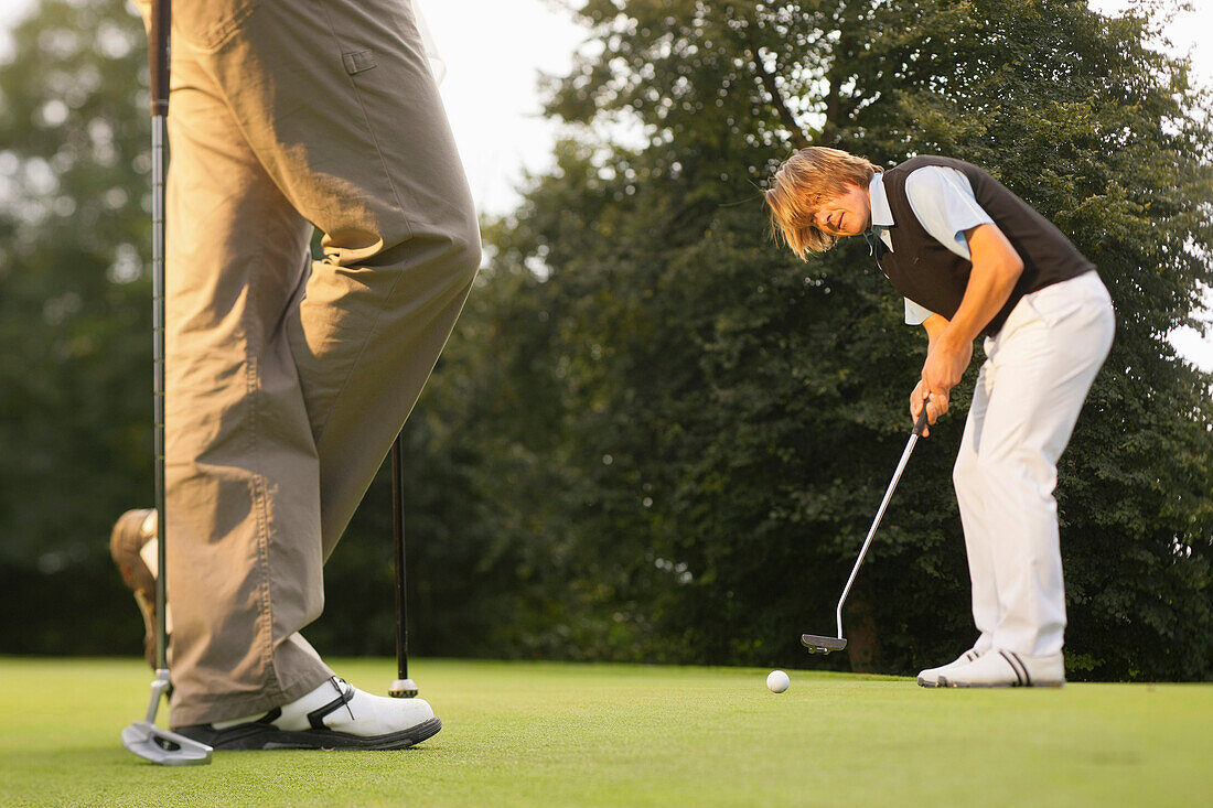 Golfer putting, Strasslach-Dingharting, Bavaria, Germany