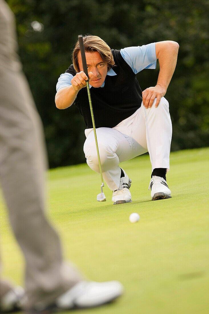 Golfer putting, Strasslach-Dingharting, Bavaria, Germany