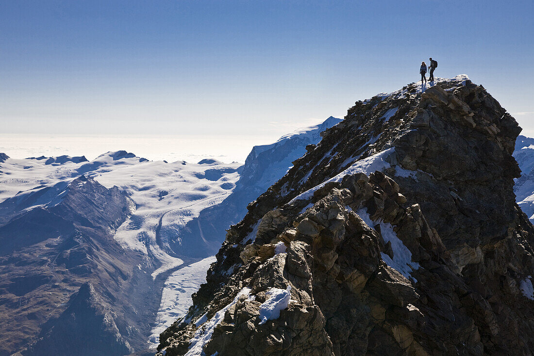 Two mountaineers on summit of mount Matterhorn, Canton of Valais, Switzerland