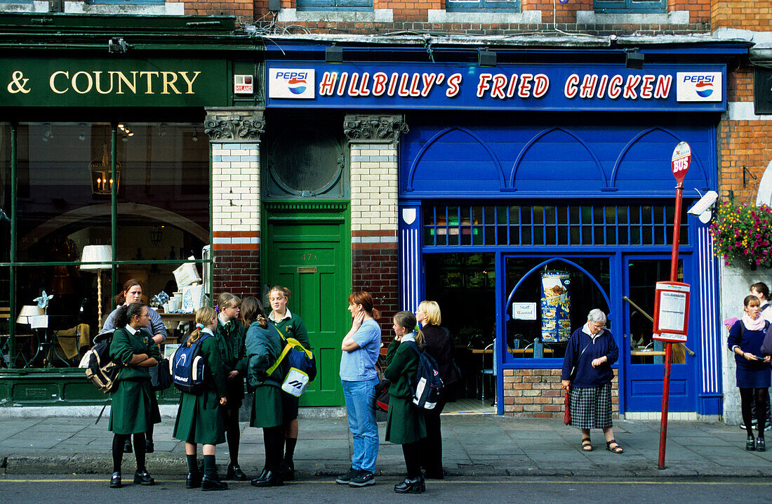 Europe, Great Britain, Ireland, Co. Cork, people waiting at a bus stop in Cobh