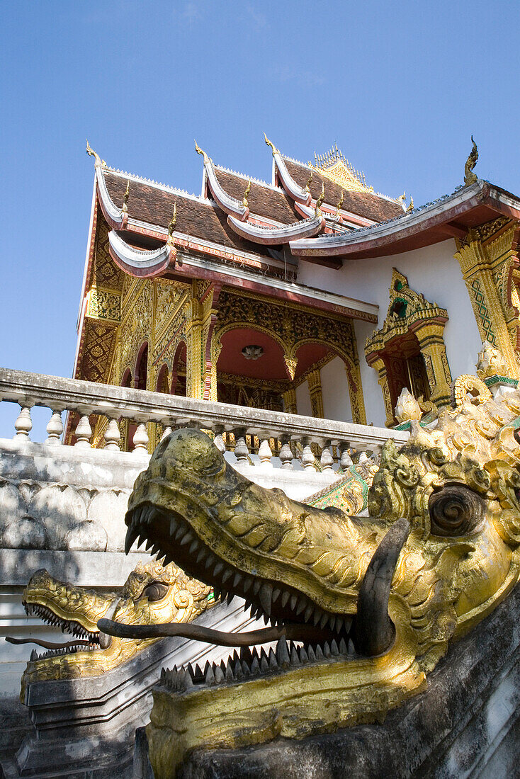 Treppenaufgang mit Drachenköpfen zum Tempel Ho Phra Bang unter blauem Himmel, Luang Prabang, Laos