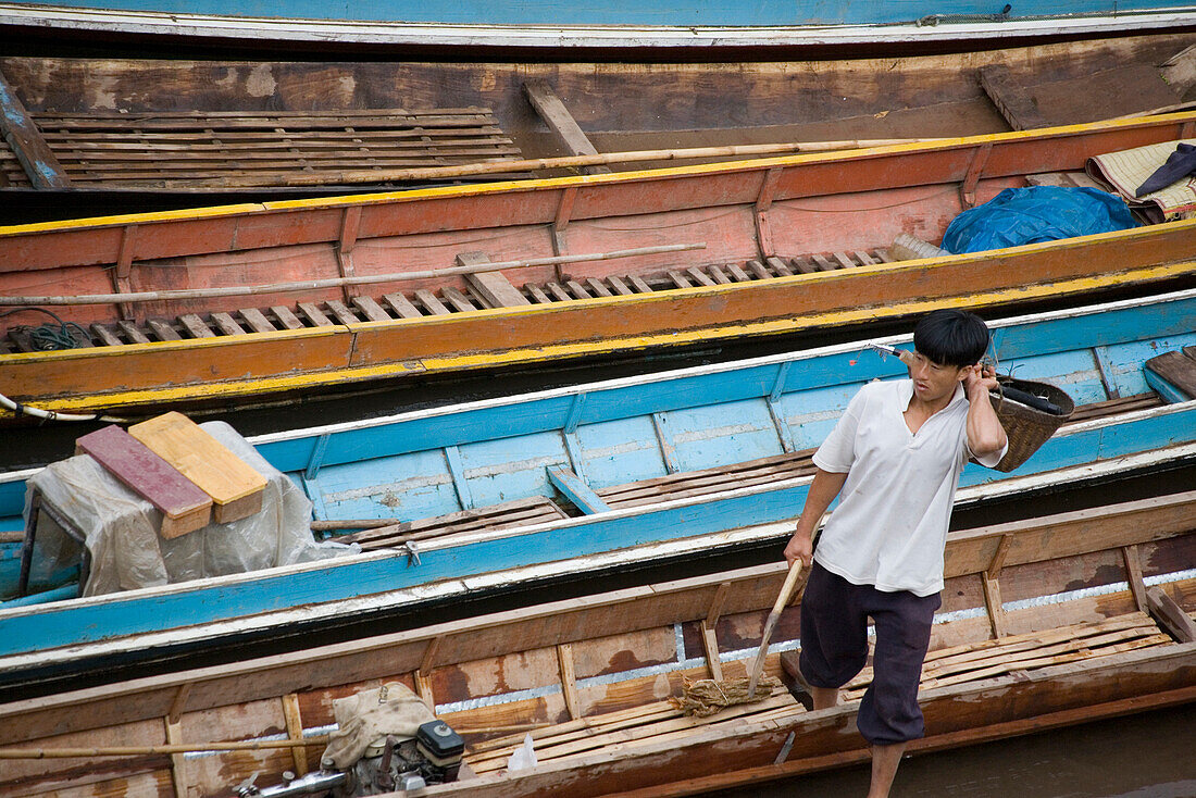 Fisherman in front of narrow boats, Luang Prabang province, Laos