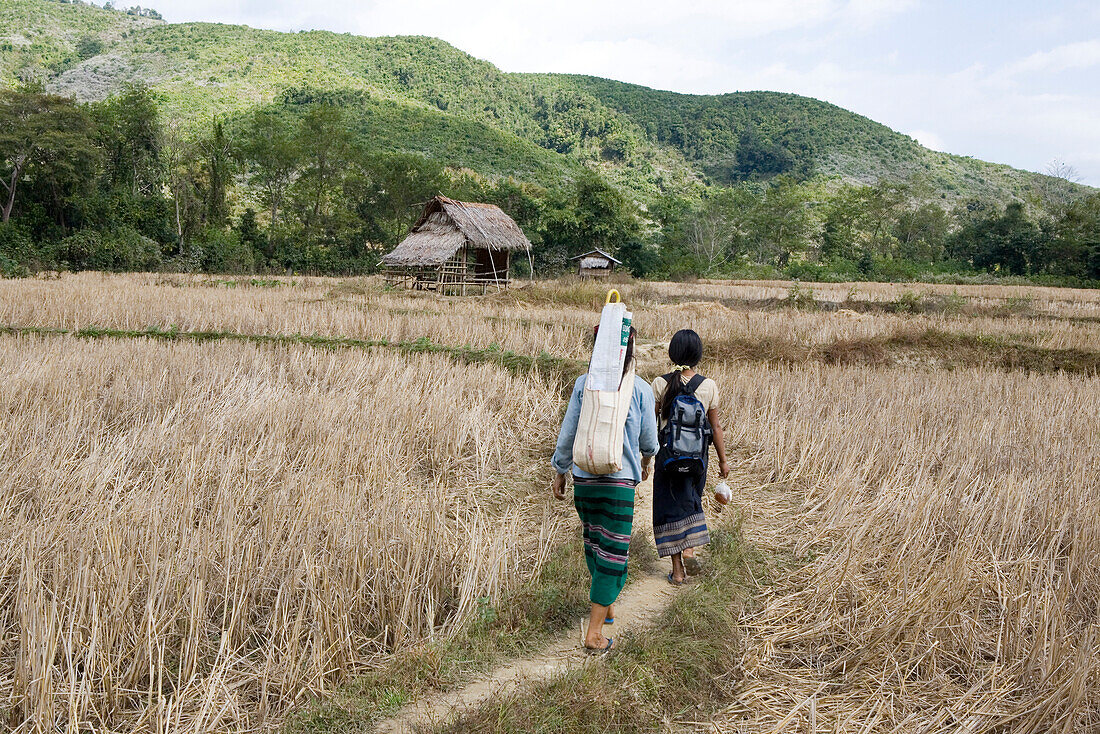 Zwei Frauen gehen auf einem Weg durch Felder, Provinz Luang Prabang, Laos