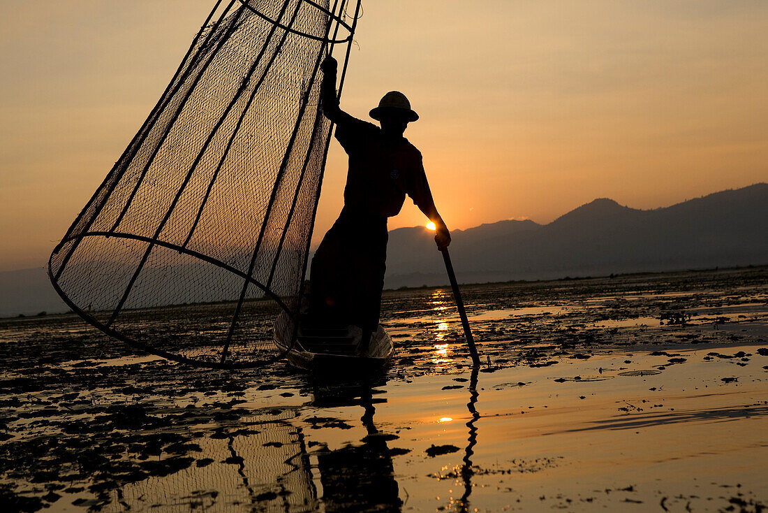Intha Fischer auf seinem Fischerboot auf dem Inle See bei Sonnenuntergang, Shan Staat, Myanmar, Burma